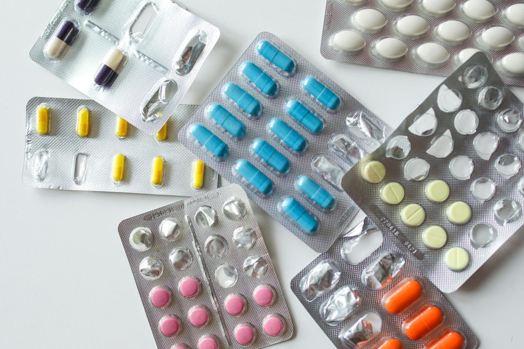 Colorful assortment of pills and capsules in blister packs for healthcare and medication usage.