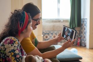 A family enjoys a video call at home in Portugal, sharing joyful moments together.